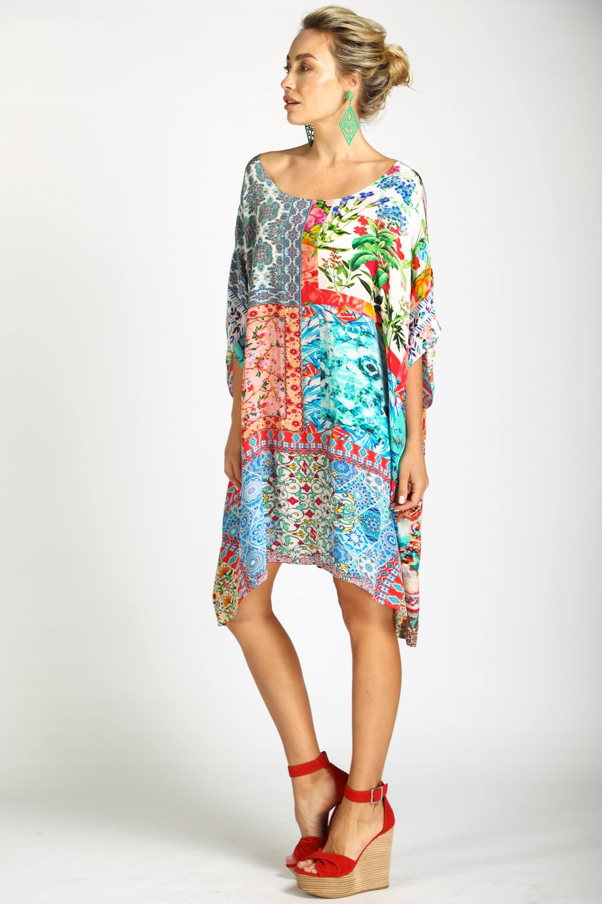 A versatile Short Box Kaftan, styled off-the-shoulder to showcase its fluid, oversized silhouette. The Damascus kaftan dress can be worn as a top or a mini-dress, featuring a striking, colorful patchwork print.