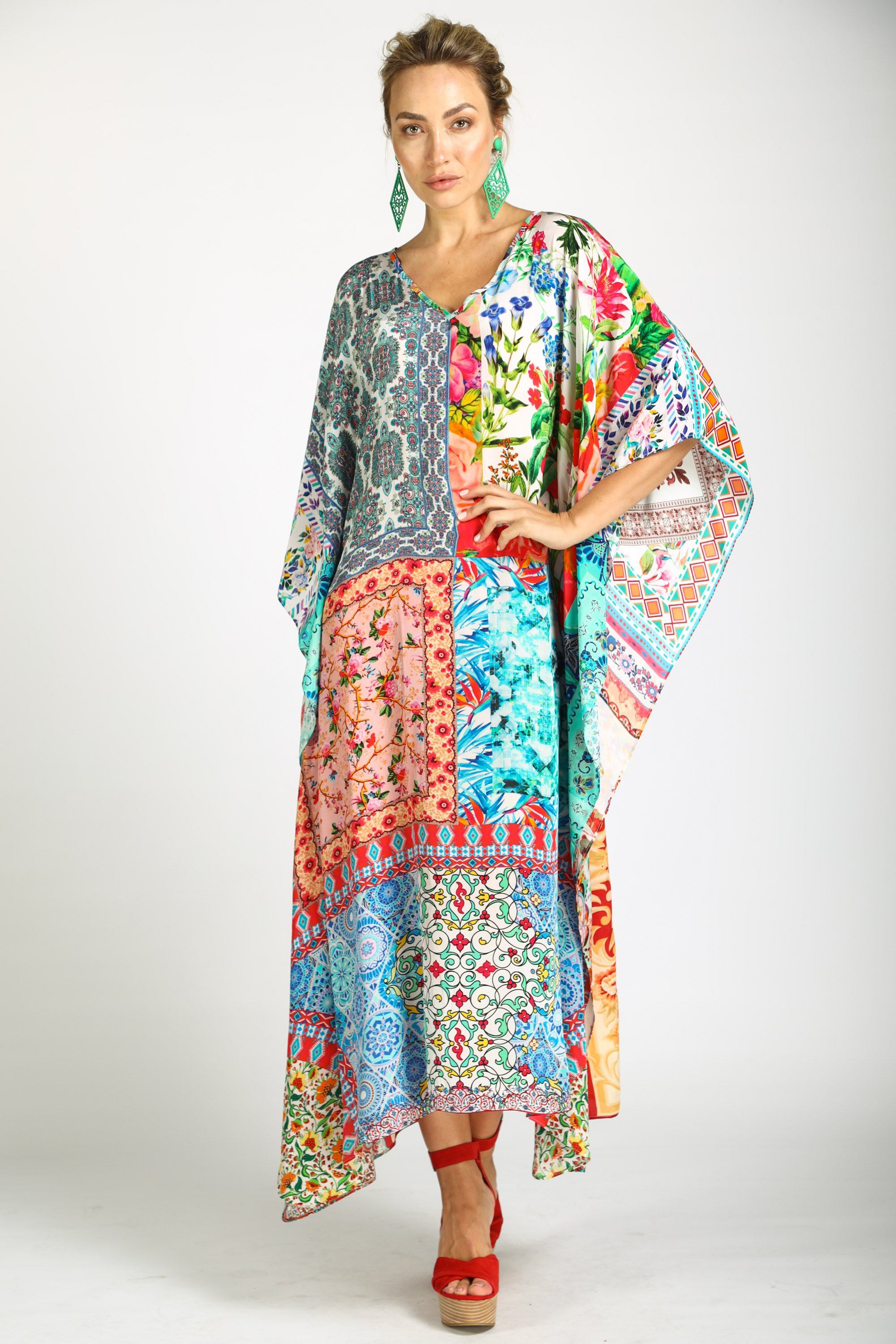 Angled view of long kaftan dress in bright floral print, showing the movement of the sheer fabric.