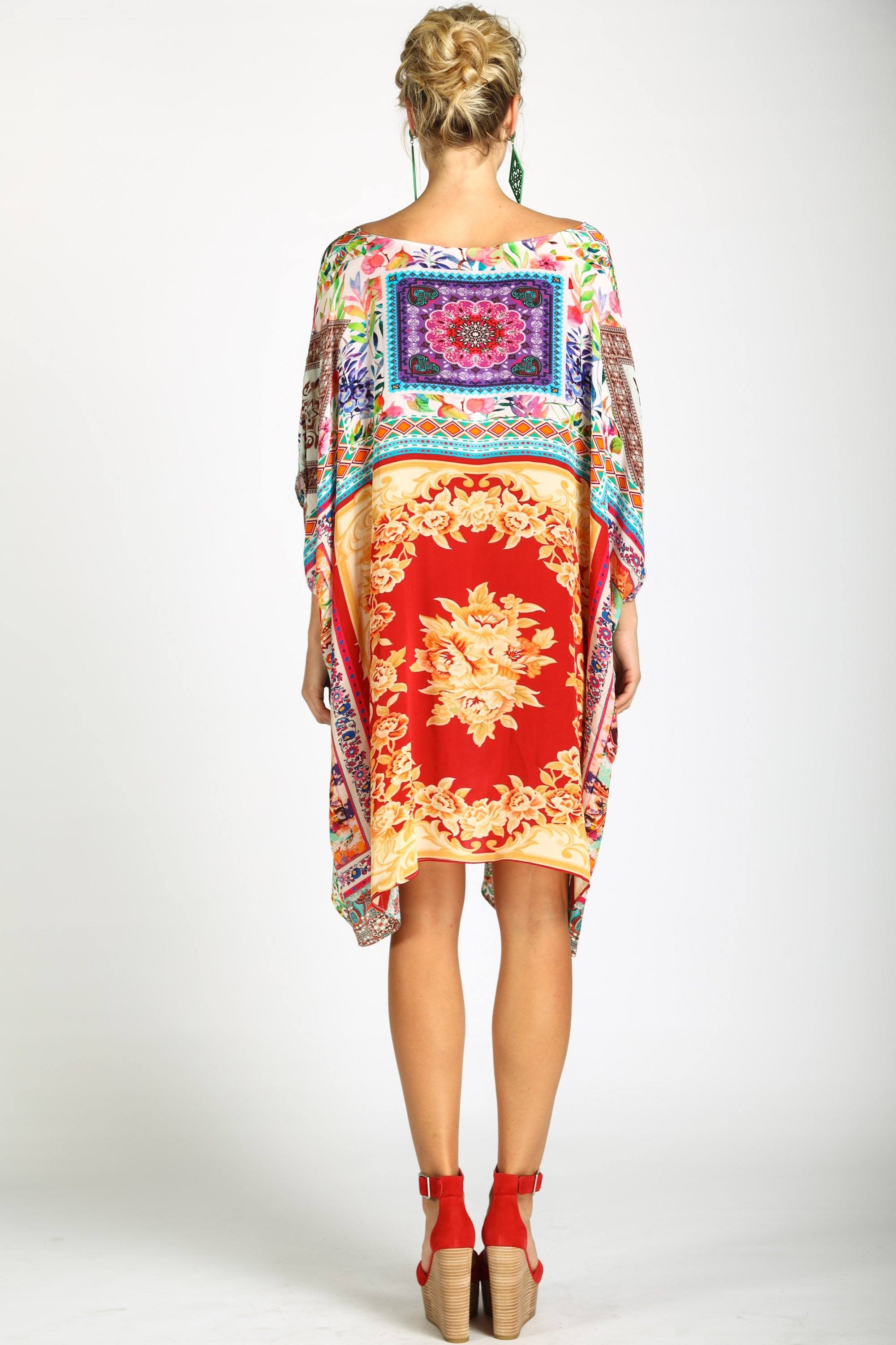 Back View A versatile Short Box Kaftan, styled off-the-shoulder to showcase its fluid, oversized silhouette. The Damascus kaftan dress can be worn as a top or a mini-dress, featuring a striking, colorful patchwork print.