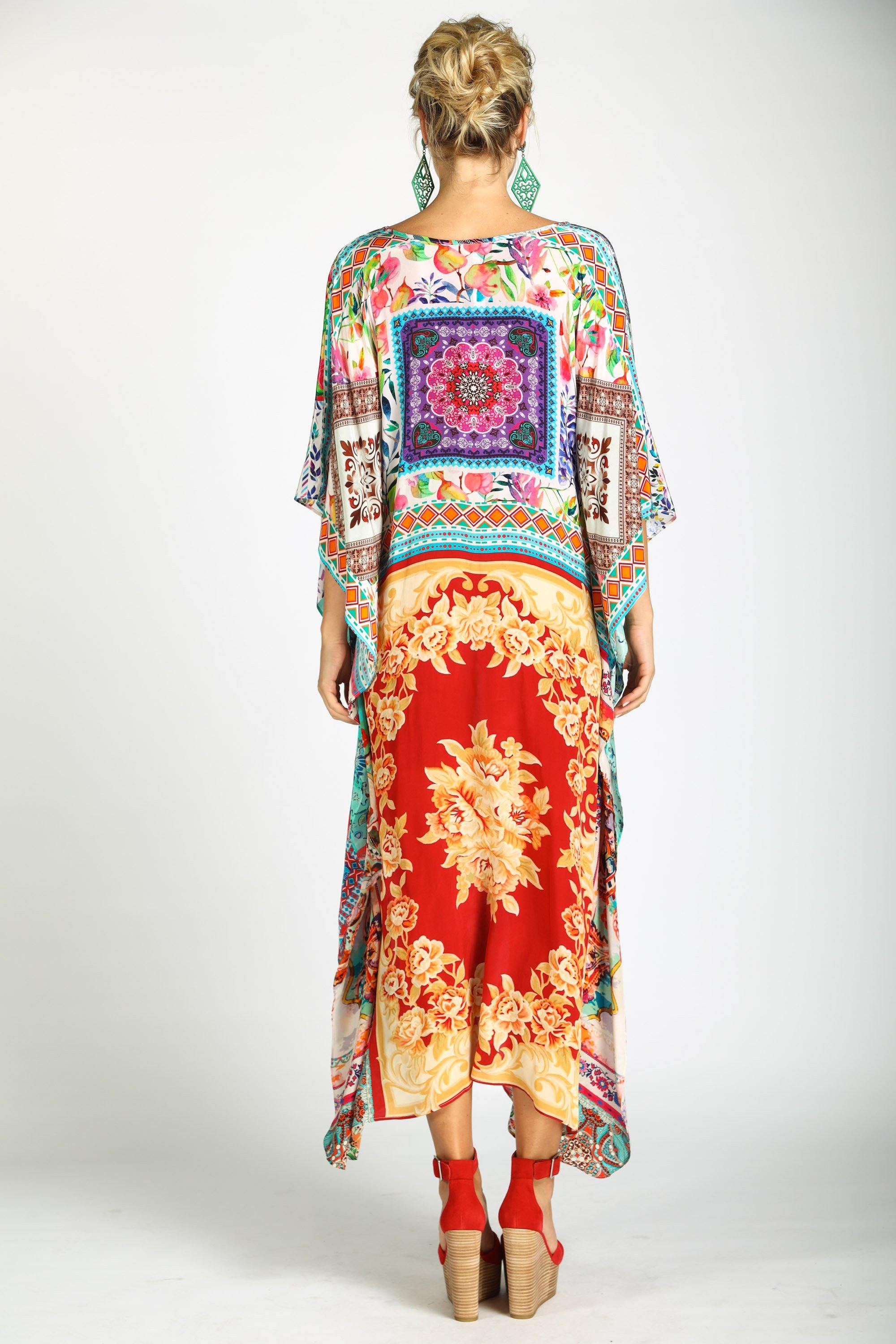 Back view Long, flowing kaftan dress in a bright floral print with pink, orange, yellow, and blue colors.