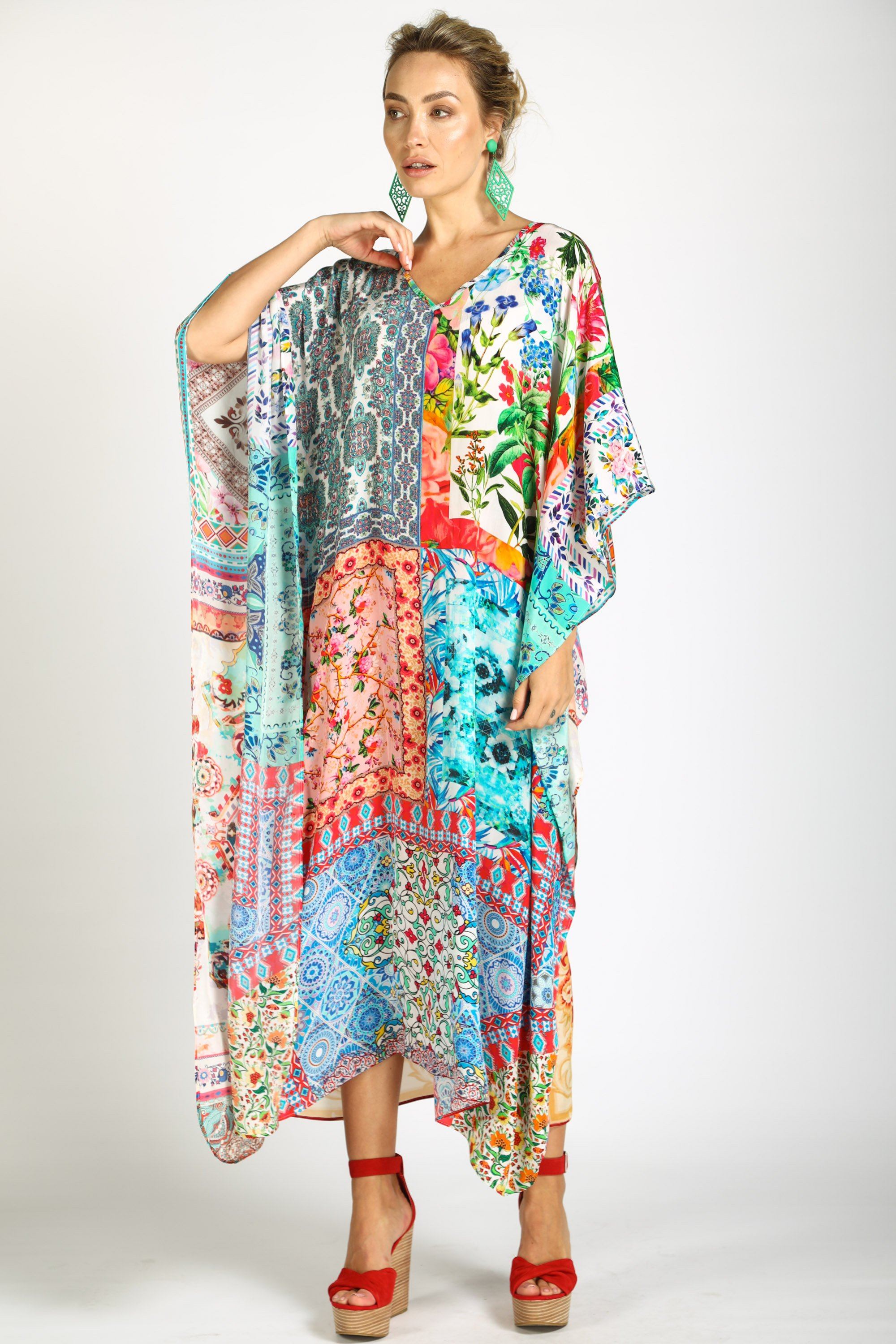 Long, flowing kaftan dress in a bright florl print with pink, orange, yellow, and blue colors.