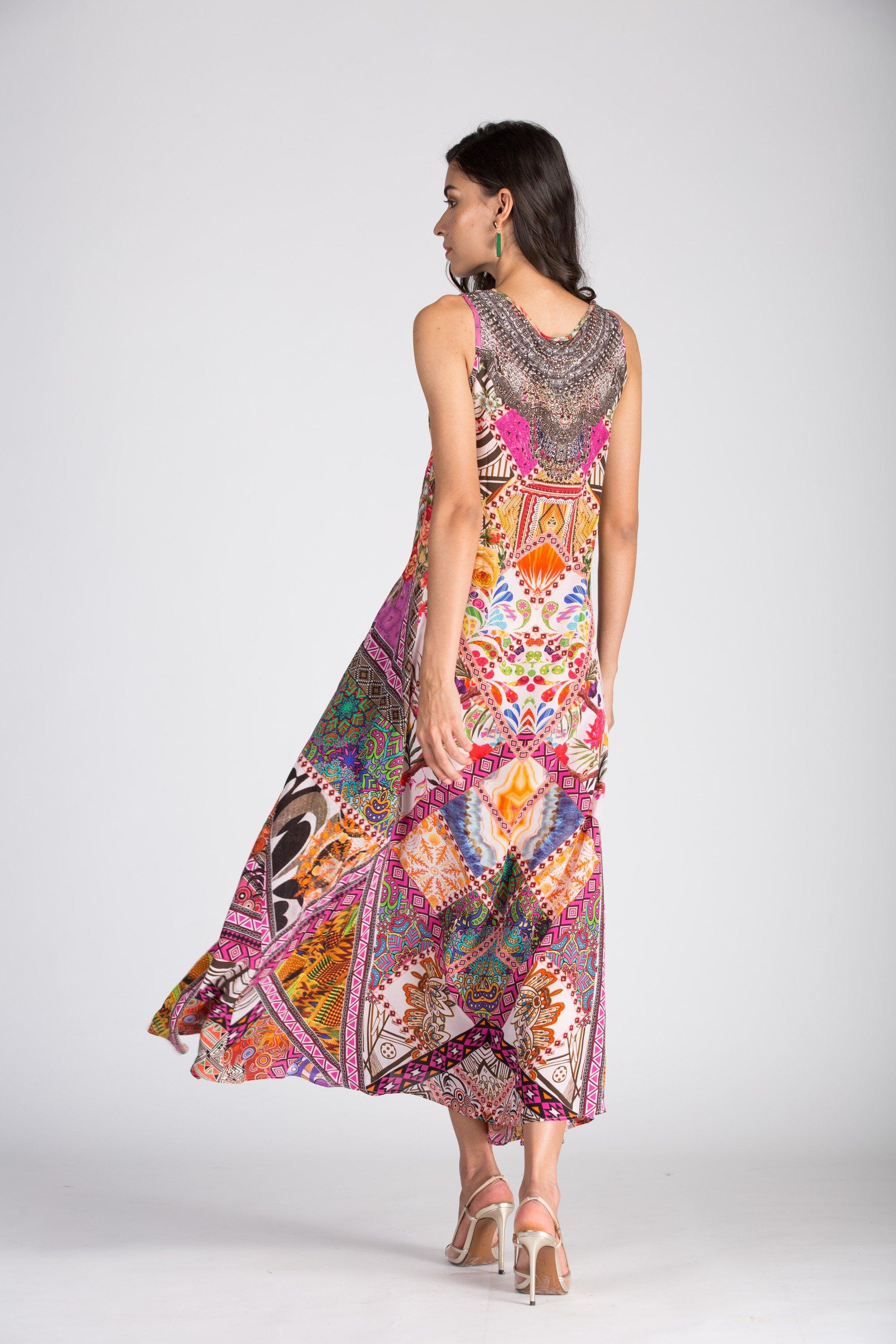 Sleeveless maxi dress in the colorful Tunisia print, shown flowing while the model walks. The print features diamond-shaped tiles in pink, orange, and gold.